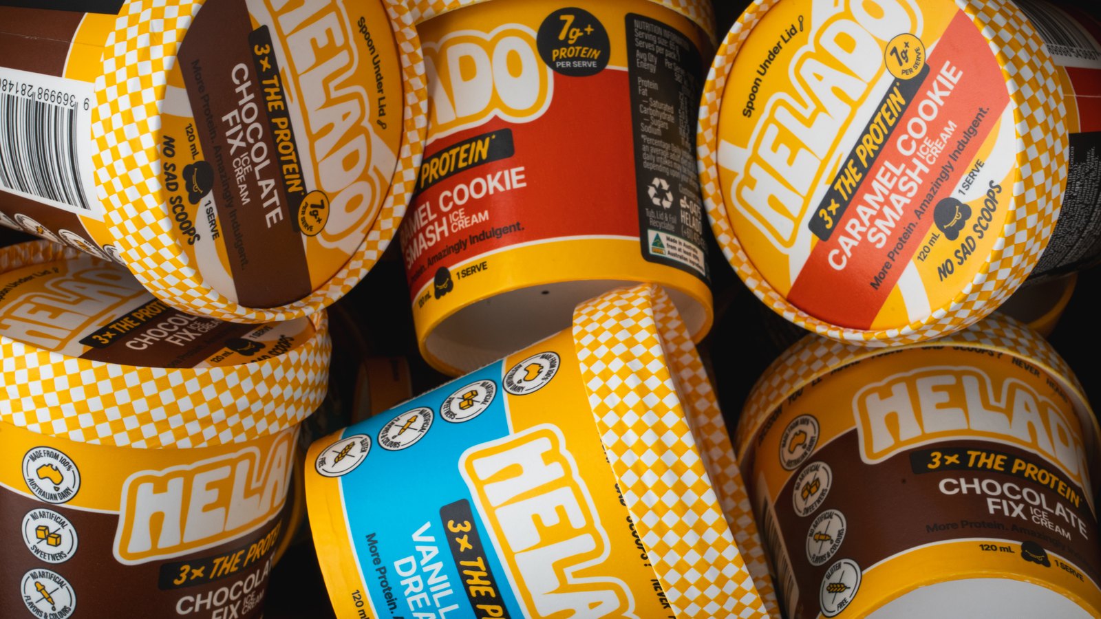 A pile of Helado cups, lids and printed panels facing up