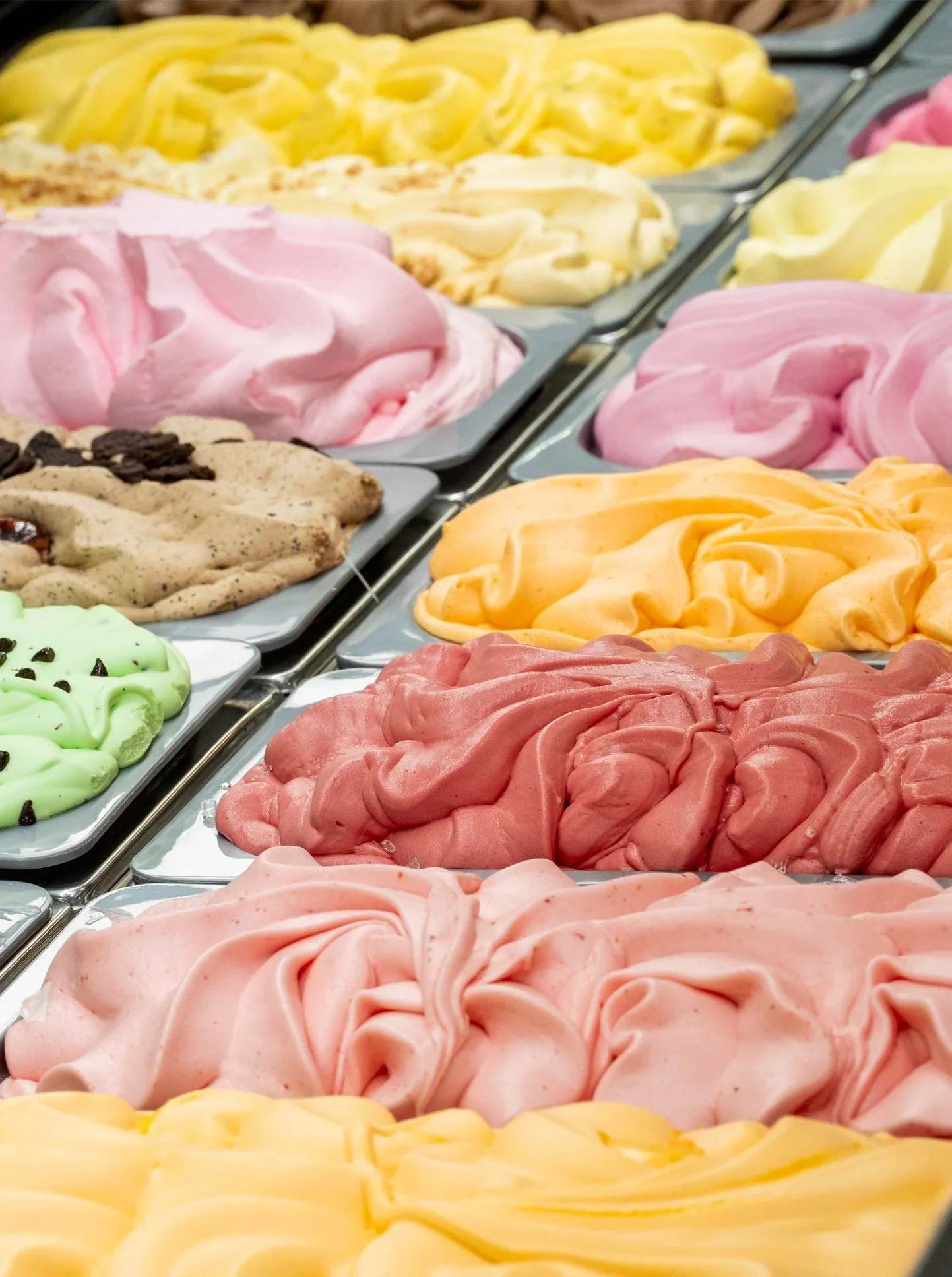 A gelato cabinet, ten flavours in stainless trays
