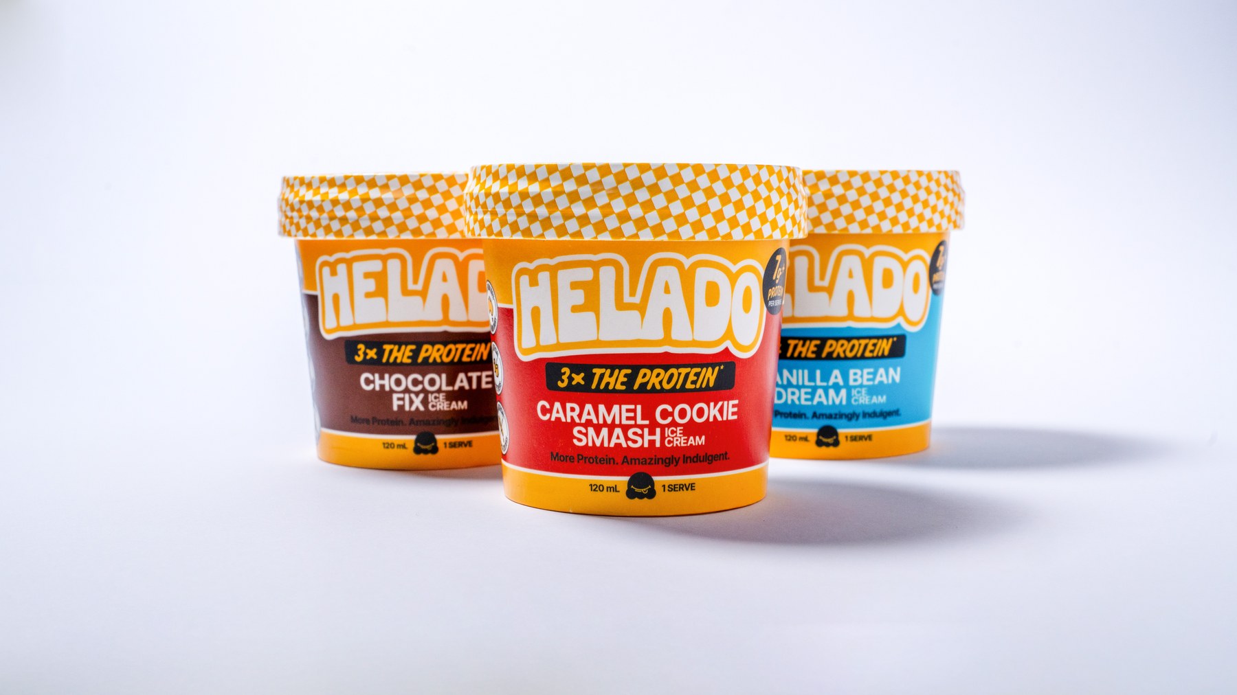 Three Helado cups standing together with their labels facing out, chocolate, caramel and vanilla
